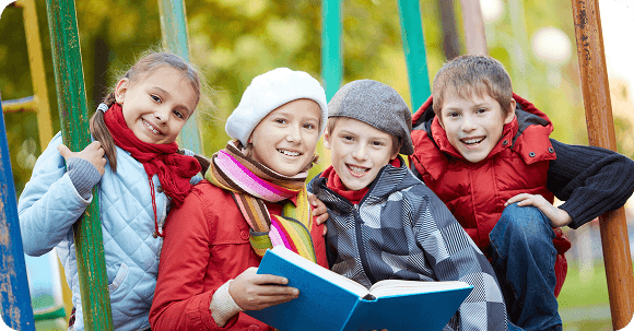 Children reading outdoors in a playground